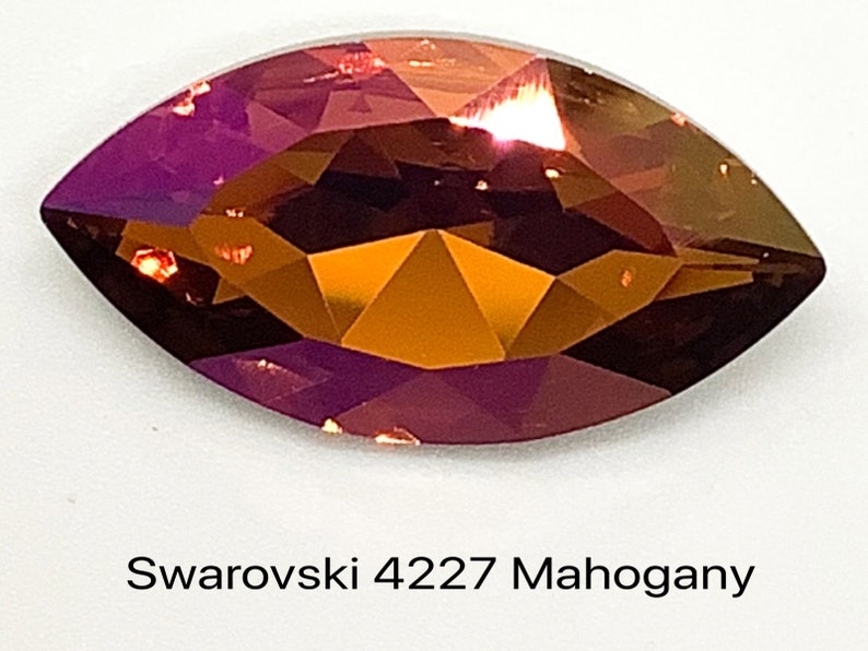 Peut inclure: Gros plan sur un seul cristal Swarovski facett&eacute; de couleur acajou en forme de marquise. Le cristal r&eacute;fl&eacute;chit la lumi&egrave;re, r&eacute;v&eacute;lant ses facettes.