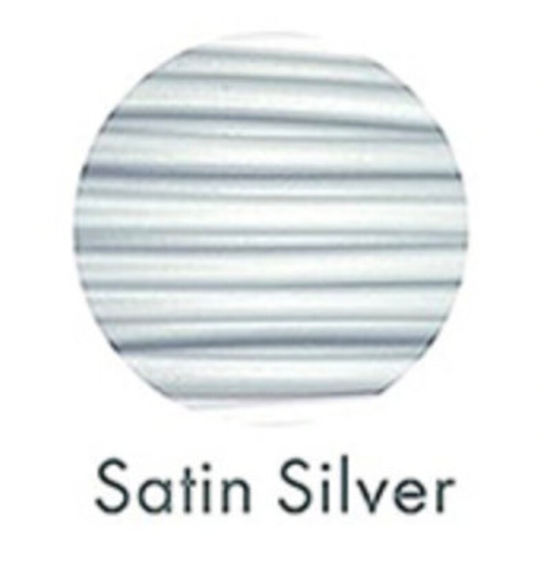 May include: A circular swatch of satin silver fabric with horizontal lines. The text "Satin Silver" is displayed below the swatch in a simple, sans-serif font. The fabric appears to have a subtle sheen.