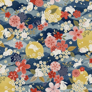 May include: A blue and white fabric with a repeating pattern of pink and white flowers, yellow moons, and white rabbits. The fabric has a traditional Japanese design.