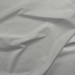 May include: A close-up of a smooth, white fabric with soft folds and wrinkles.