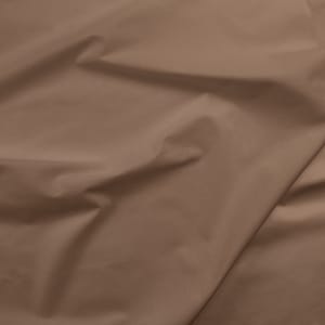 May include: A close-up of a smooth, brown fabric with a subtle sheen. The fabric is folded and draped, creating soft, flowing lines.