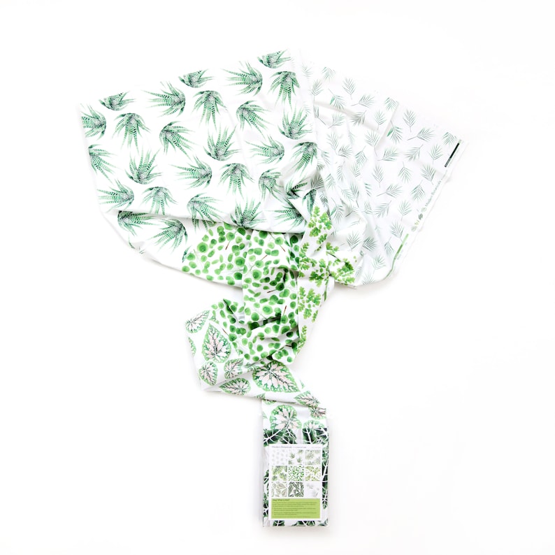 May include: A set of four fabric squares with different green leaf patterns on a white background. The fabric squares are folded and arranged in a spiral shape. The fabric squares are labeled "Botanical Collection" and "Made in the USA".