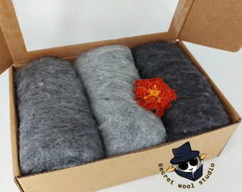 May include: Three rolls of grey wool roving in a cardboard box. The box has a label that says "Secret Wool Studio".