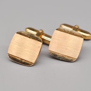 Boutons de manchette vintage en métal doré.