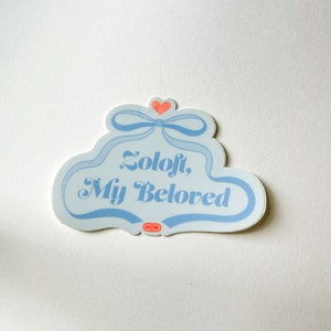 May include: A blue and white sticker with a heart and a bow. The sticker says "Zoloft, My Beloved".