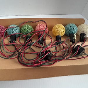 May include: A set of eight vintage Christmas lights with colorful, textured bulbs. The lights are wired with red and green wires and are packaged in a brown cardboard box.