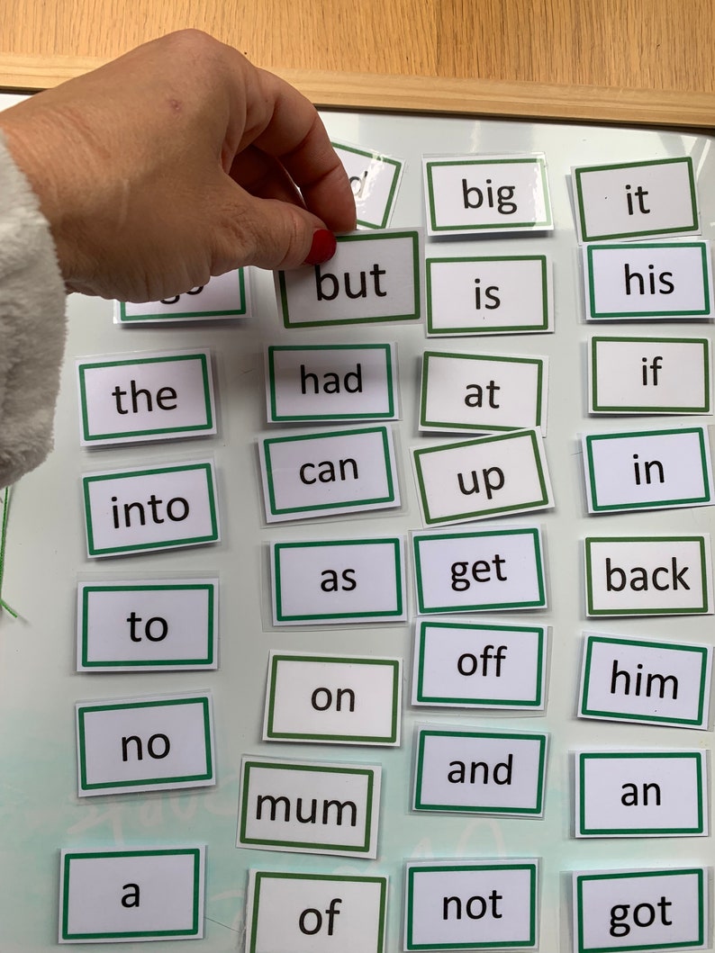 May include: A set of 24 magnetic word tiles with green borders and white backgrounds. The words include "big", "it", "but", "is", "his", "the", "had", "if", "at", "can", "up", "in", "into", "as", "get", "back", "to", "off", "on", "him", "no", "and", "mum", "an", "a", "of", "not", and "got".