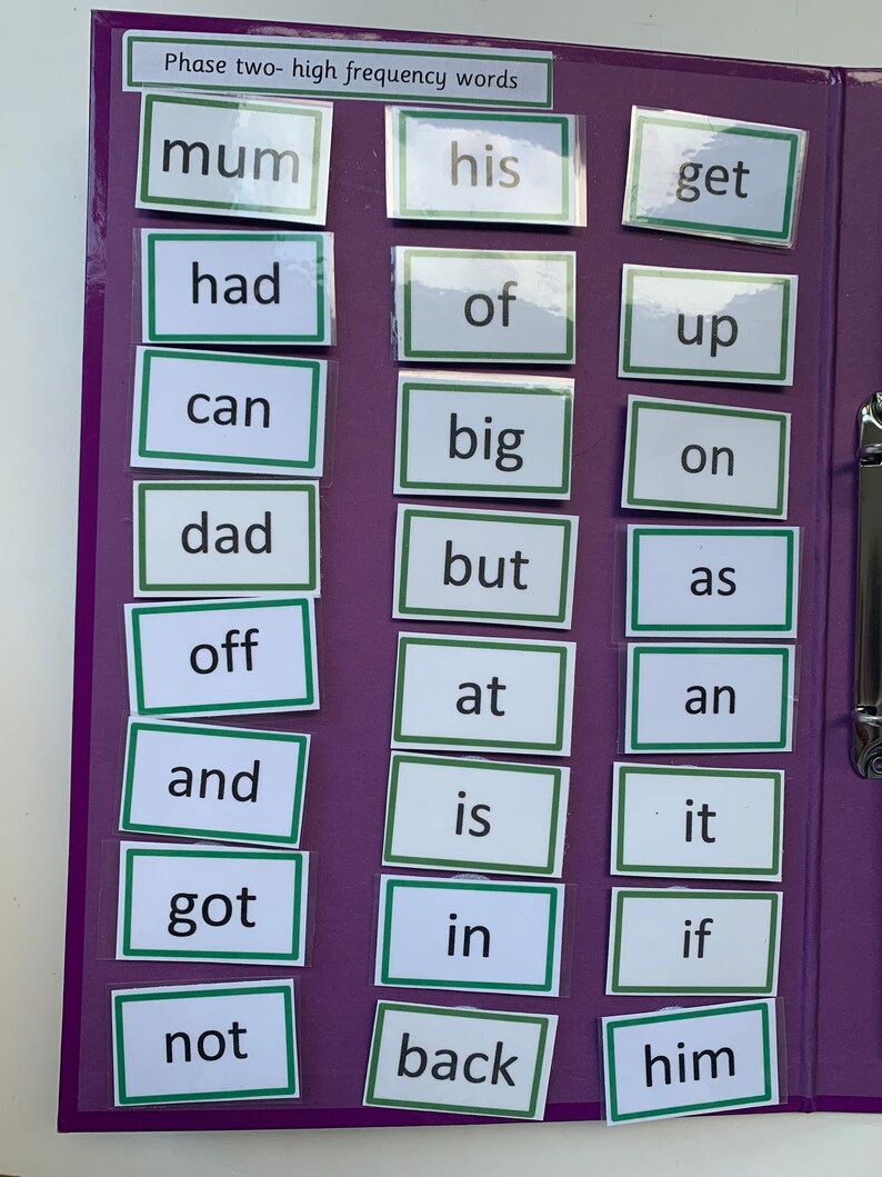 May include: A purple binder with clear pockets containing white cards with green borders. Each card has a high frequency word written in black text. The words are: mum, his, get, had, of, up, can, big, on, dad, but, as, off, at, an, and, is, it, got, in, if, not, back, him.
