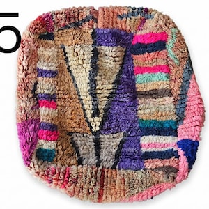 Puede incluir: Una alfombra colorida y texturizada con un dise&ntilde;o geom&eacute;trico. La alfombra presenta una variedad de colores, incluyendo rosa, morado, marr&oacute;n y azul. El n&uacute;mero "15" est&aacute; en la esquina superior izquierda. La alfombra tiene una apariencia suave y afelpada.