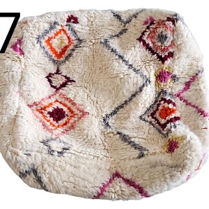 Puede incluir: Puf texturizado color crema con un patr&oacute;n geom&eacute;trico de diamantes en tonos naranja, rosa y burdeos. El n&uacute;mero 17 est&aacute; en la esquina superior izquierda. Este puf decorativo a&ntilde;ade un toque bohemio a cualquier espacio habitable.
