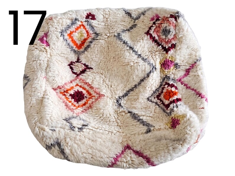 Puede incluir: Puf texturizado color crema con un patr&oacute;n geom&eacute;trico de diamantes en tonos naranja, rosa y burdeos. El n&uacute;mero 17 est&aacute; en la esquina superior izquierda. Este puf decorativo a&ntilde;ade un toque bohemio a cualquier espacio habitable.