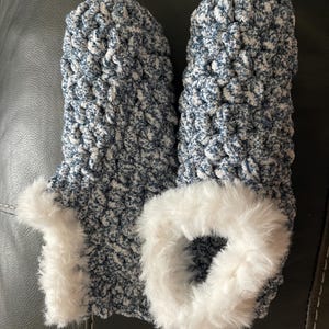 May include: A pair of blue and white knitted slippers with a white faux fur trim.