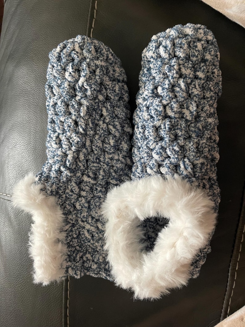 May include: A pair of blue and white knitted slippers with a white faux fur trim.