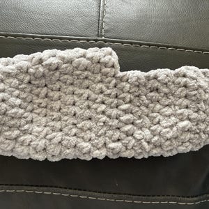 May include: A gray crocheted slipper with a fuzzy texture.