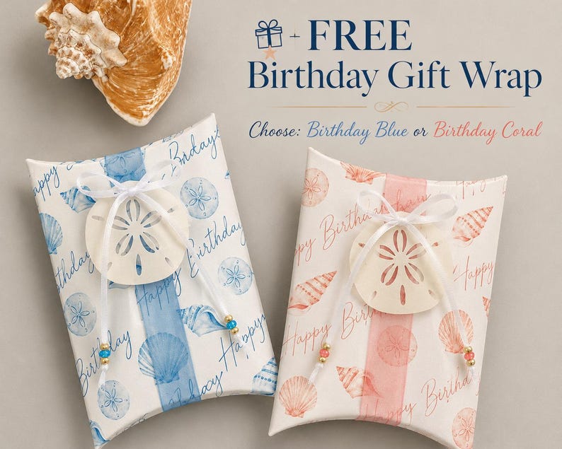 May include: Two rectangular pillow boxes with a seashell pattern and the text "Happy Birthday". One box features blue shells and text, the other coral shells and text. Each is tied with a white ribbon and a sand dollar ornament with small beads.