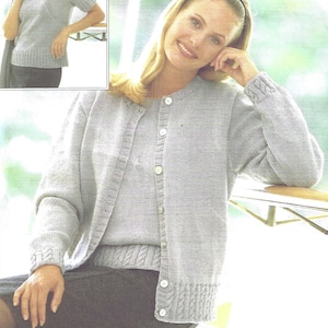 May include: A light gray knitted cardigan with a matching top underneath. The cardigan has a button closure and long sleeves. The top has short sleeves and a round neckline.