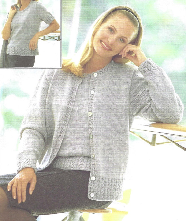 May include: A light gray knitted cardigan with a matching top underneath. The cardigan has a button closure and long sleeves. The top has short sleeves and a round neckline.