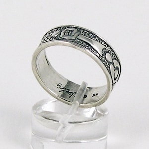 May include: Silver ring with an intricate Celtic knot design. The ring is engraved with the word "Sterling" and the number "925".