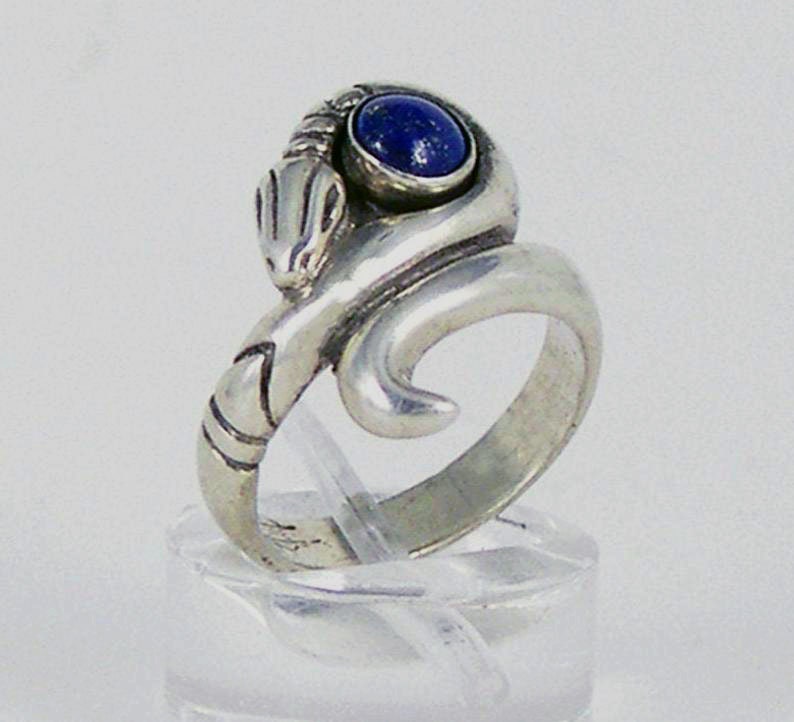 May include: A silver ring featuring a coiled snake design with a blue lapis lazuli gemstone.