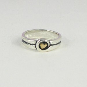 May include: A silver band ring with a gold heart charm. The ring has a textured, hammered finish.