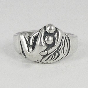 May include: A silver ring with a design of two figures holding three round beads.