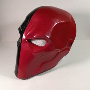 Puede incluir: Una m&aacute;scara de pl&aacute;stico roja y negra con una abertura de malla para el ojo. La m&aacute;scara est&aacute; dise&ntilde;ada para parecerse a la m&aacute;scara de un superh&eacute;roe.