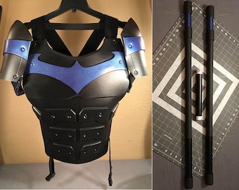 May include: Black and blue chest armor with a bat symbol, and two black staffs with blue accents.