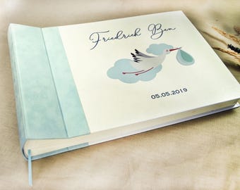 Personalized baby album for birth with flying stork and baby in cloth in light blue and cream with velours / velvet, ribbon bookmark, structure