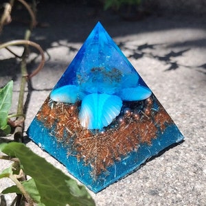 May include: A blue resin pyramid with a seashell and copper accents. The pyramid is filled with copper flakes and small copper beads.