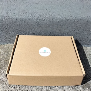 May include: A brown cardboard box with a white circle sticker that says "RubyDoo Gifts".