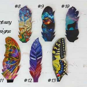 May include: A selection of fantasy-themed feather designs. The feathers display diverse patterns, including a galaxy, a wolf silhouette, and butterfly wings. The text "Fantasy Designs" is also visible.