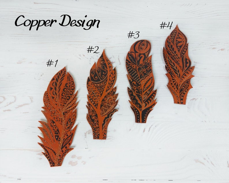 Puede incluir: Cuatro dise&ntilde;os de plumas de color cobre con intrincados patrones negros se muestran sobre un fondo de madera blanca. El texto "Copper Design" est&aacute; escrito en cursiva en la parte superior. Cada pluma est&aacute; numerada del #1 al #4.