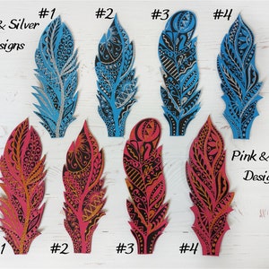 May include: Eight decorative feather bookmarks, four with blue and silver glitter designs and four with pink and gold glitter designs. Each bookmark is numbered 1 through 4.