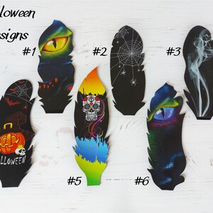 May include: Six Halloween-themed feather designs are displayed. The feathers showcase spooky illustrations such as a glowing eye, spiderwebs, a skull, and a pumpkin with the word "Halloween". Each design is numbered for identification.