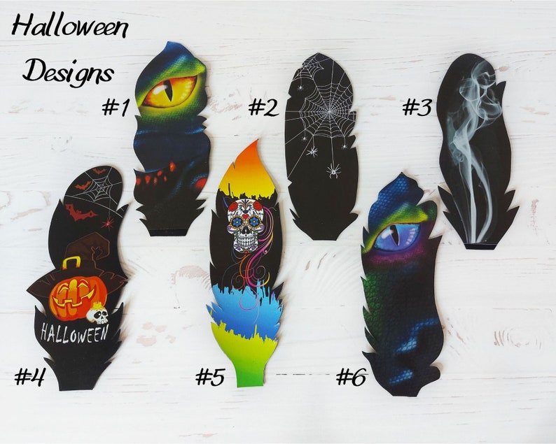 May include: Six Halloween-themed feather designs are displayed. The feathers showcase spooky illustrations such as a glowing eye, spiderwebs, a skull, and a pumpkin with the word "Halloween". Each design is numbered for identification.
