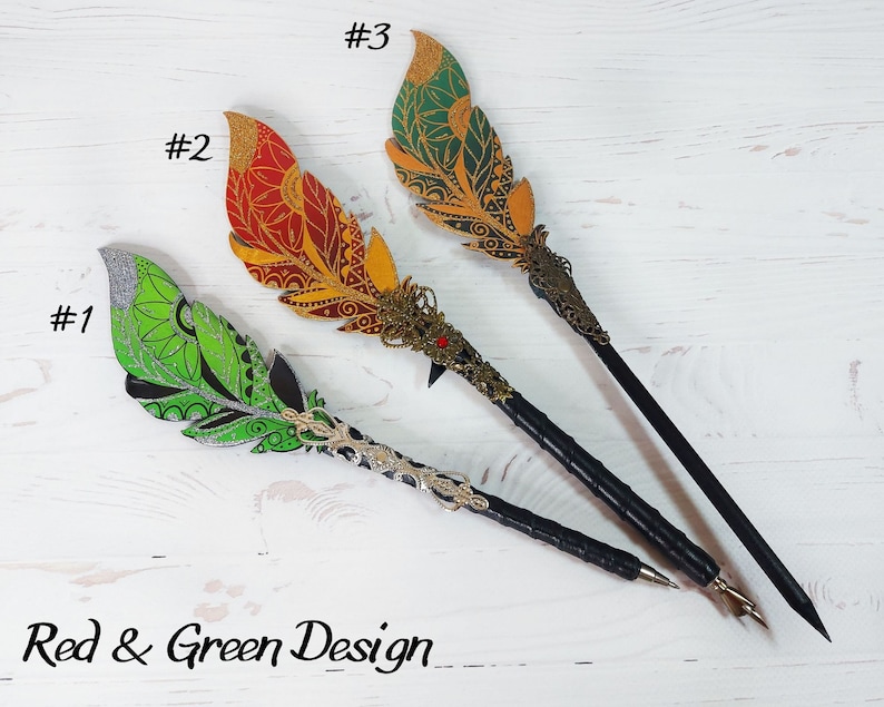 May include: Three decorative feather pens with black shafts and ornate metal tips. The feathers are painted in green, red, and gold with intricate designs. The pens are labeled #1, #2, and #3. The text "Red & Green Design" is at the bottom of the image.