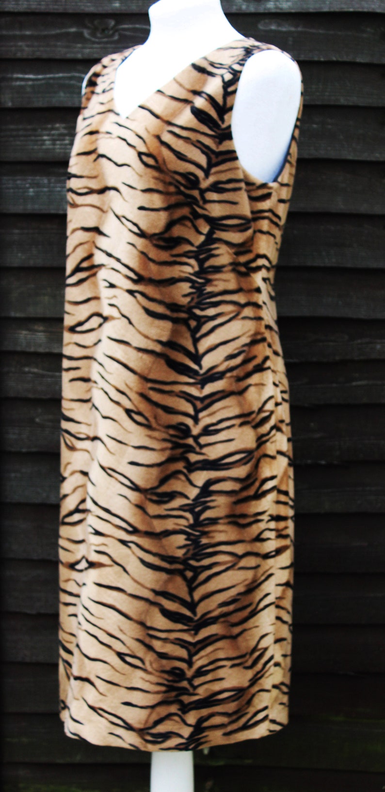 K&ouml;nnte beinhalten: Ein &auml;rmelloses Kleid mit einem Tigerstreifenmuster in Braun- und Schwarzt&ouml;nen.
