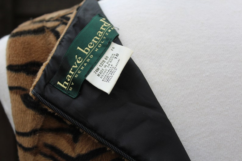 K&ouml;nnte beinhalten: Ein braunes und schwarzes gestreiftes Kleid mit einem schwarzen Rei&szlig;verschluss und einem wei&szlig;en Etikett mit der Aufschrift "harv&eacute; benard by benard holtzman 74M 1370 69 MADE IN RUSSIA HECHO EN RUSIA POLIESTER SIZE/TALLA 10 FO".