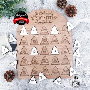 May include: Wooden advent calendar with a tree-shaped design. The calendar features the text "The Clark Family ACTS OF KINDNESS advent calendar" and includes 25 numbered tree cutouts with acts of kindness. Includes a "Original Brand Design" logo.