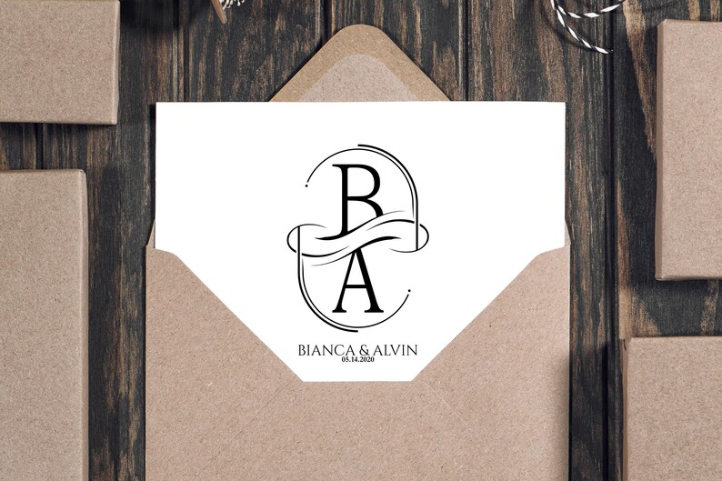 Puede incluir: Una tarjeta blanca con un dise&ntilde;o de monograma negro con las letras "B" y "A" dentro de un marco ovalado, con los nombres "BIANCA & ALVIN" y la fecha "05.14.2020" impresos debajo. La tarjeta est&aacute; dentro de un sobre marr&oacute;n, con otras cajas marrones en el fondo.