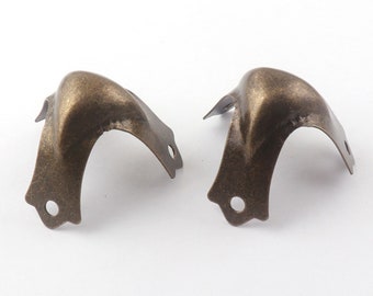 May include: Two antique gold corner protectors with a decorative design. The protectors are made of metal and have a distressed finish.