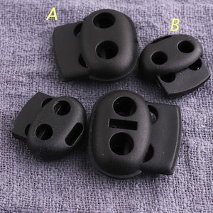 Puede incluir: Cuatro cierres de cordón de plástico negro con dos o tres agujeros. Los cierres de cordón están diseñados para asegurar cordones o correas.