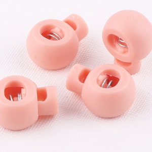 Puede incluir: Cuatro cierres de palanca de plástico rosa con cierres de resorte de metal. Los cierres están diseñados para usarse con cordones o correas.