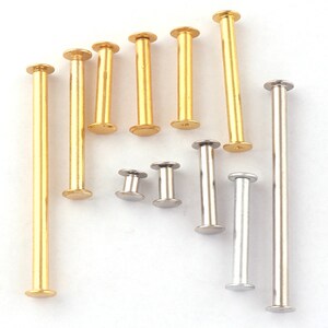 Könnte beinhalten: Sortiment aus goldenen und silbernen Metallnieten. Die Nieten sind in verschiedenen Längen und haben einen flachen Kopf.