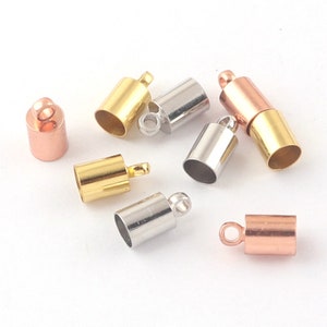 May include: Assortment of metal end caps for jewelry making. The end caps are in gold, silver, and rose gold colors. Each end cap has a loop for attaching to a cord or chain.
