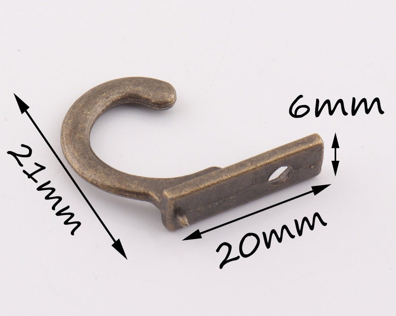 May include: A bronze-colored metal hook with a 2.1-inch long hook and a 0.8-inch wide base. The base has a 0.6-inch diameter hole for mounting.