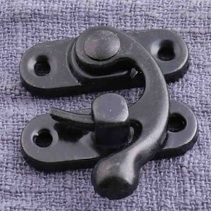 May include: Black metal clasp with a hook and a spring-loaded latch. The clasp is designed to be used for securing two pieces of fabric together.