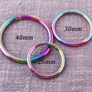 May include: Three iridescent metal rings in different sizes. The largest ring is 40mm in diameter, the middle ring is 30mm in diameter, and the smallest ring is 25mm in diameter.