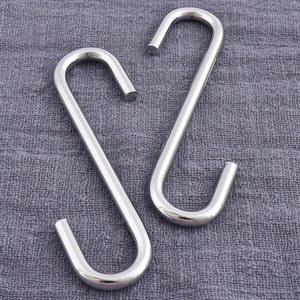 May include: Two silver S-shaped hooks, likely for hanging kitchen utensils or other items.