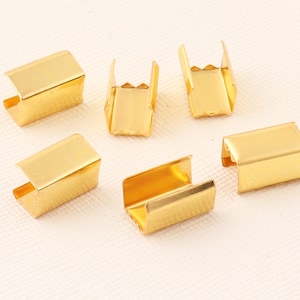 Puede incluir: Seis hebillas deslizantes de metal dorado. Las hebillas son de forma rectangular y tienen una abertura en forma de U.